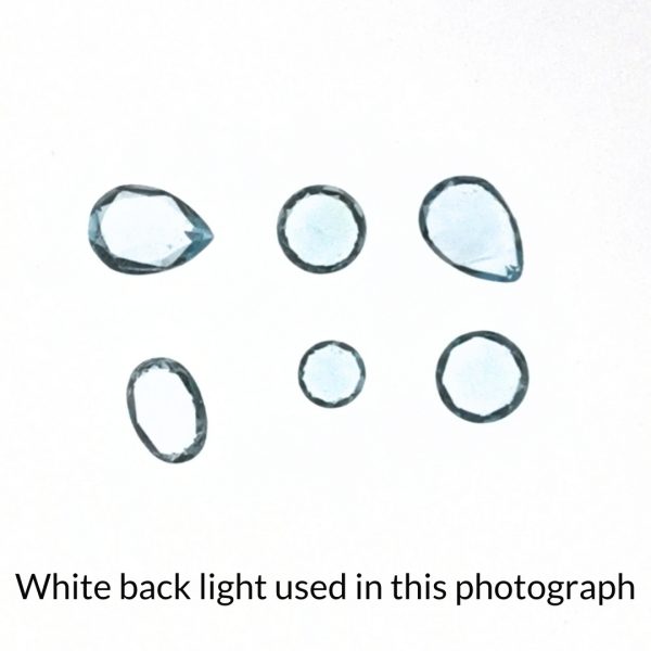 The sky blue topaz gems are being back-lit with a bright white light to show any inclusions within the gems more clearly.