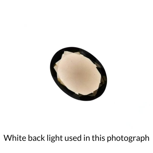 The brown smoky quartz oval gem is being back-lit with a bright white light to show any inclusions within the gem more clearly.