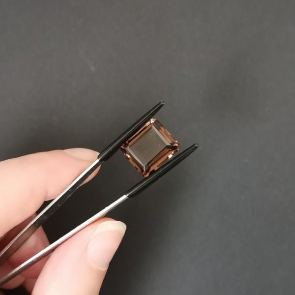 A photo of the crown area of the rich brown smoky quartz against a black background