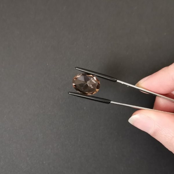 a photo of the pavilion of the brown smoky quartz oval against a black background