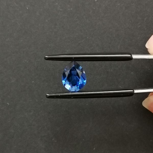 A photo of the crown area of the lab grow blue sapphire against a black background