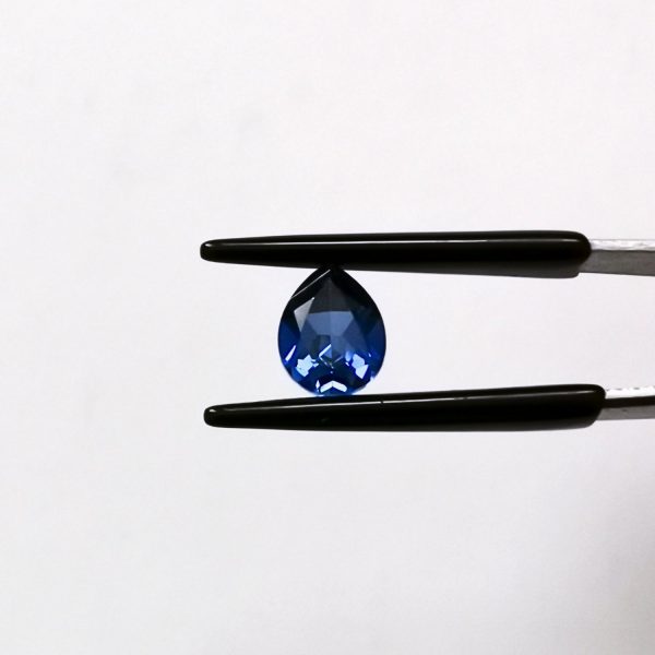 A photo of the crown area of the lab grown blue sapphire against a black background