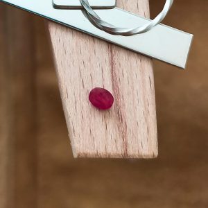 The ruby oval displayed on a jewellers bench peg with some sterling silver sheet and wire.