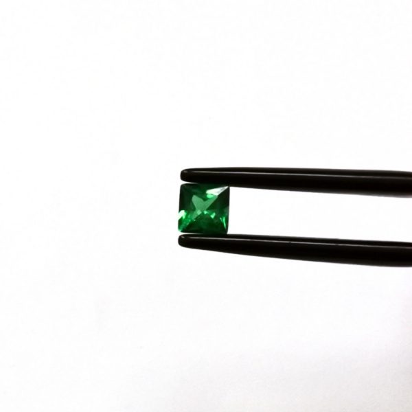 A photo of the crown area of the rich green tsavorite garnet against a white background