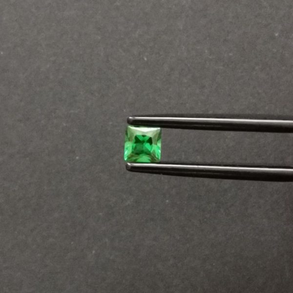 A photo of the crown area of the bright green tsavorite garnet against a black background
