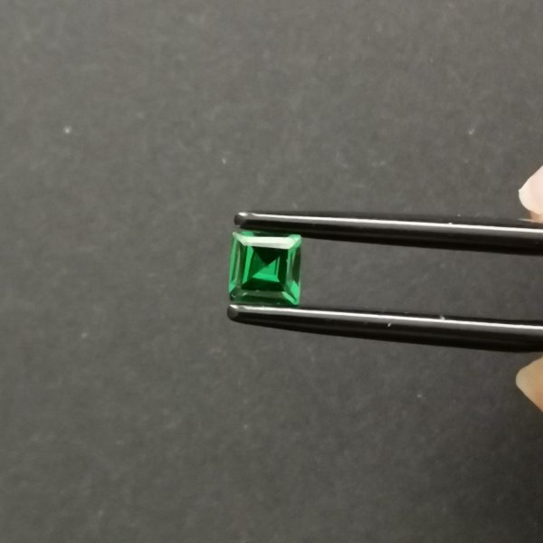 A photo of the crown area of the rich green tsavorite garnet against a black background