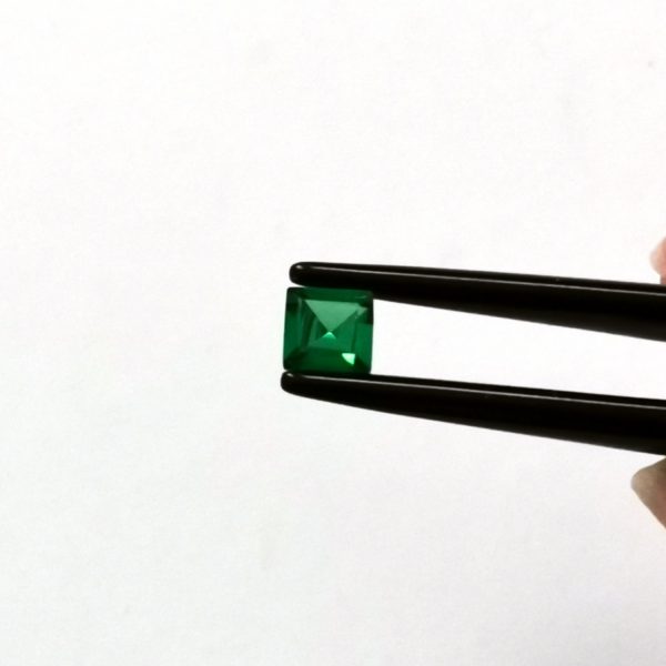 A photo of the crown area of the rich green tsavorite garnet against a white background