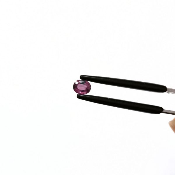 A photo of the crown area of the pinkish purple sapphire against a white background