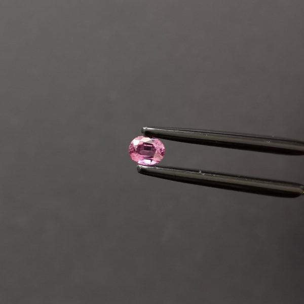 A photo of the crown area of the pinkish purple sapphire against a black background