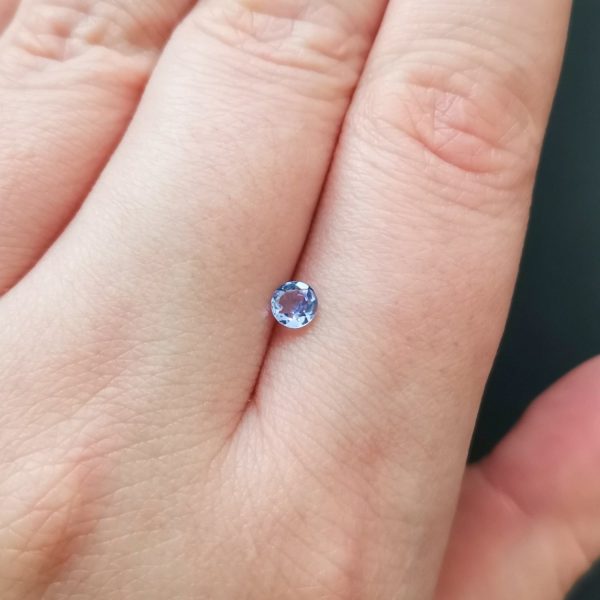 The small tazanite gemstone resting on a hand to give an idea of the gemstones size and colour.