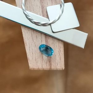 The London blue topaz oval displayed on a jewellers bench peg with some sterling silver sheet and wire.