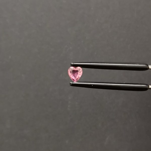 A photo of the crown area of the bright pink tourmaline against a black background