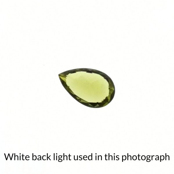 The teardrop peridot gem is being back-lit with a bright white light to show any inclusions within the gem more clearly.