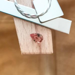 The colour change garnet teardrop displayed on a jewellers bench peg with some sterling silver sheet and wire.