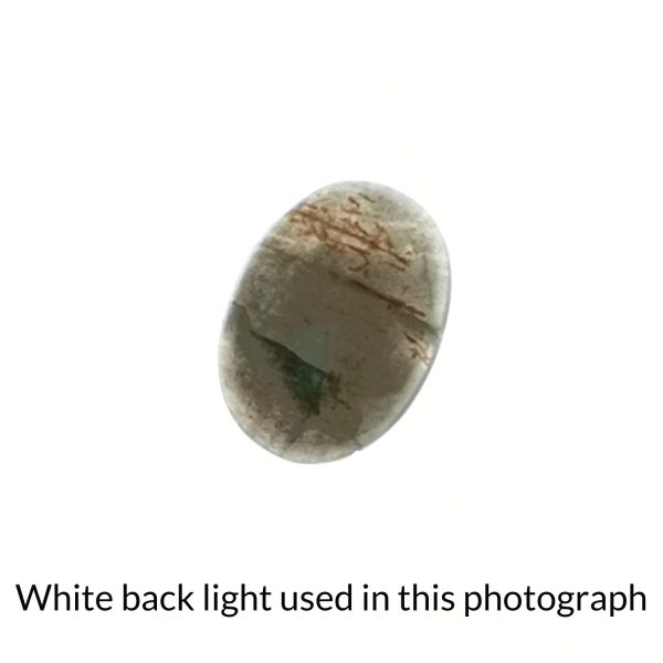 The oval labradorite gem is being back-lit with a bright white light to show any inclusions within the gem more clearly.