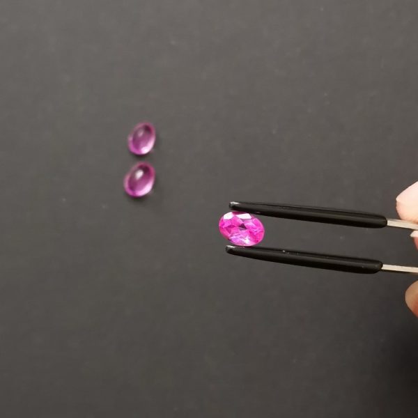 A photo of the crown area of the hot pink colour coated topaz against a black background