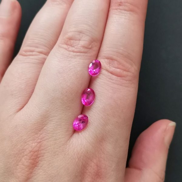 The 3 pink topaz gemstones resting on a hand to give an idea of the gemstones size and colour.