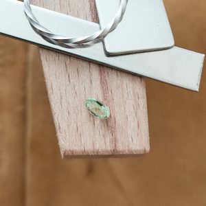 The green garnet oval displayed on a jewellers bench peg with some sterling silver sheet and wire.
