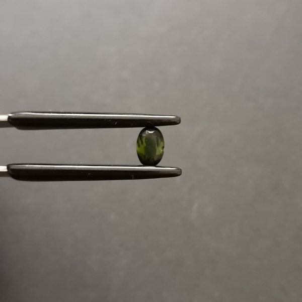 A photo of the crown area of the green tourmaline against a black background