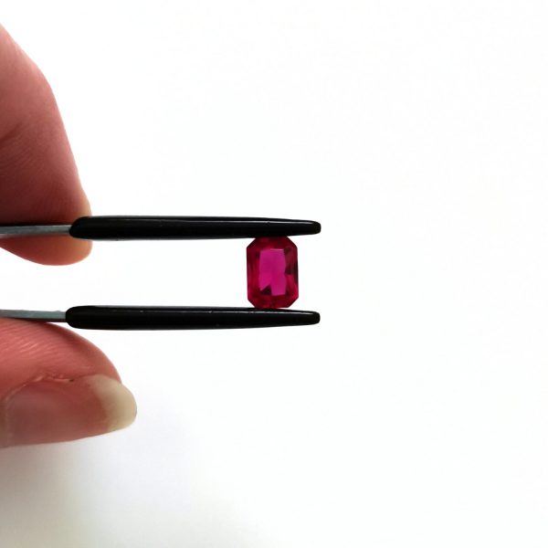 A photo of the crown area of the pinkish red lab grown ruby against a white background