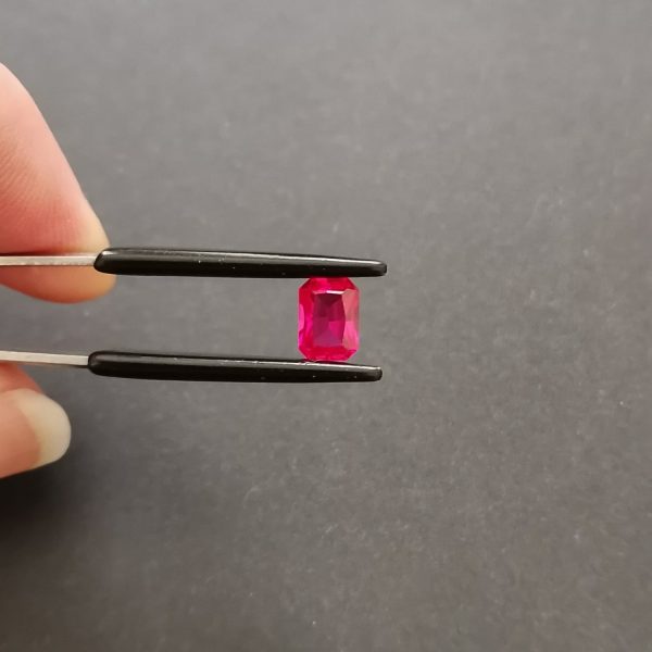A photo of the crown area of the piish red lab grown ruby against a black background
