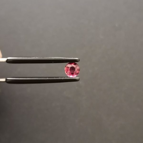 A photo of the crown area of the pink tourmaline against a black background