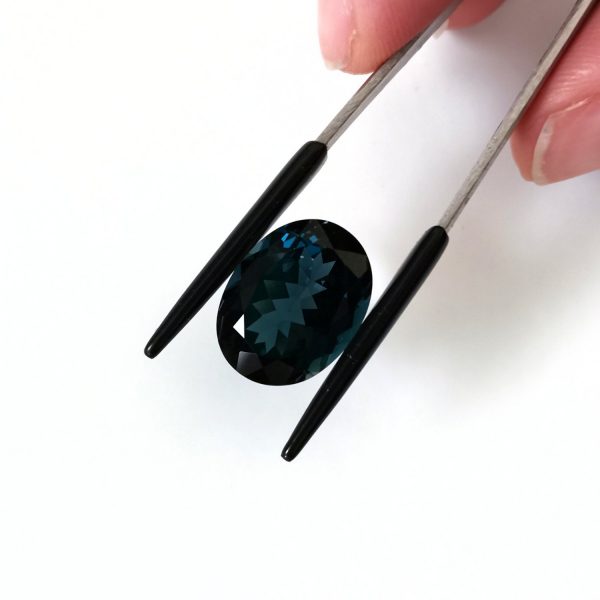 A photo of the crown area of the dark blue topaz against a white background
