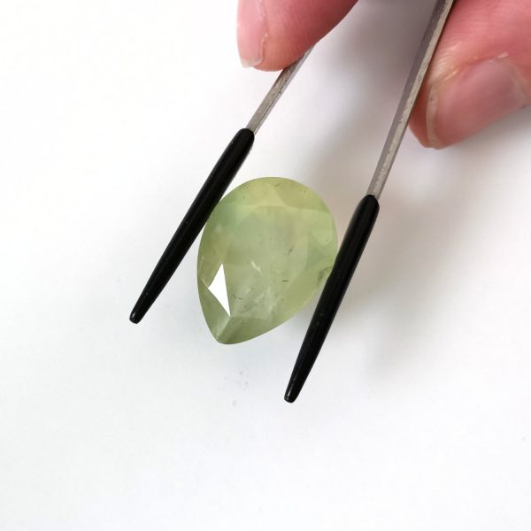 A photo of the crown area of the pale green prehnite against a white background