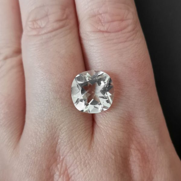 The clear quartz gemstone resting on a hand to give an idea of the gemstones size and colour.