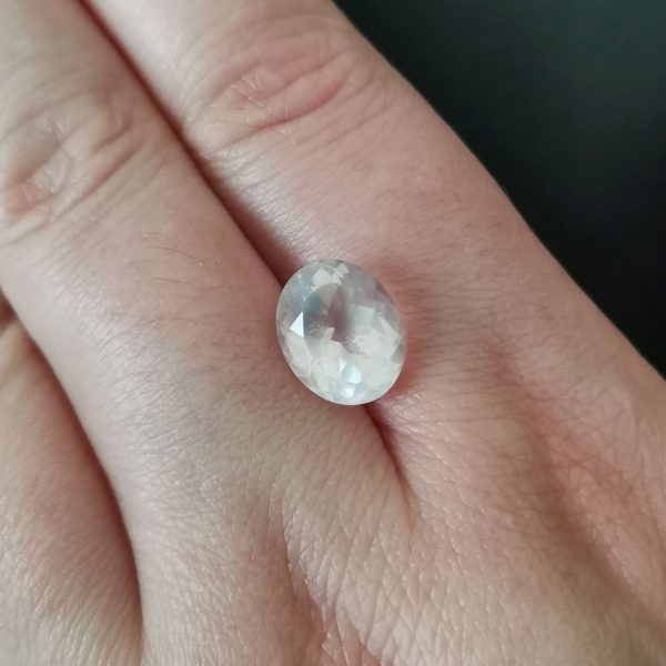 The pink rose quartz gemstone resting on a hand to give an idea of the gemstones size and colour.