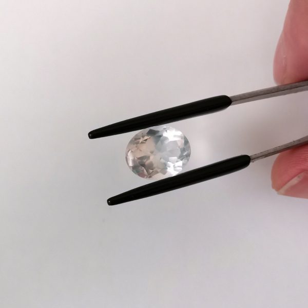 A photo of the crown area of the pale pink rose quartz against a white background