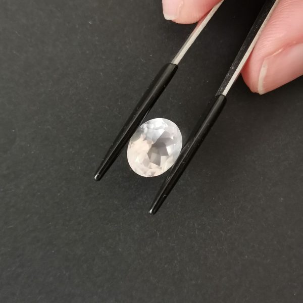 A photo of the crown area of the pale pink rose quartz against a black background