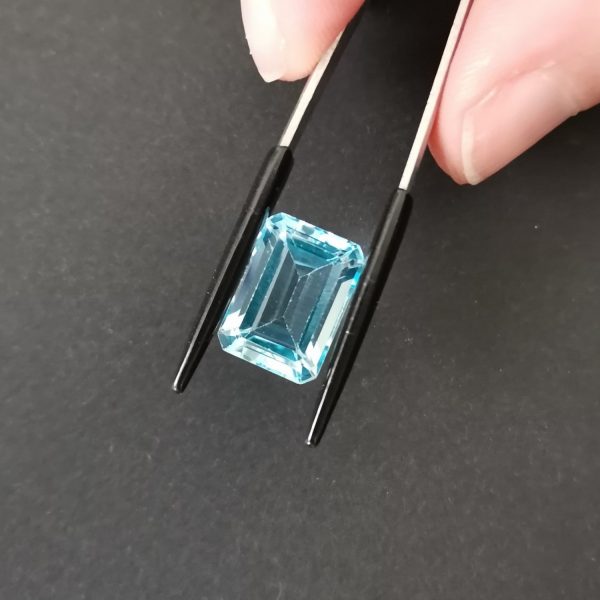 A photo of the crown area of the bright blue topaz against a black background
