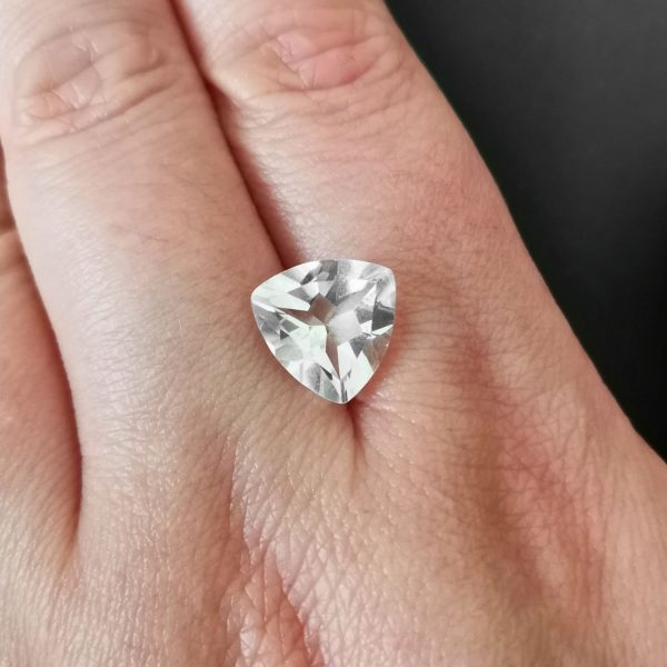 The clear quartz gemstone resting on a hand to give an idea of the gemstones size and colour.