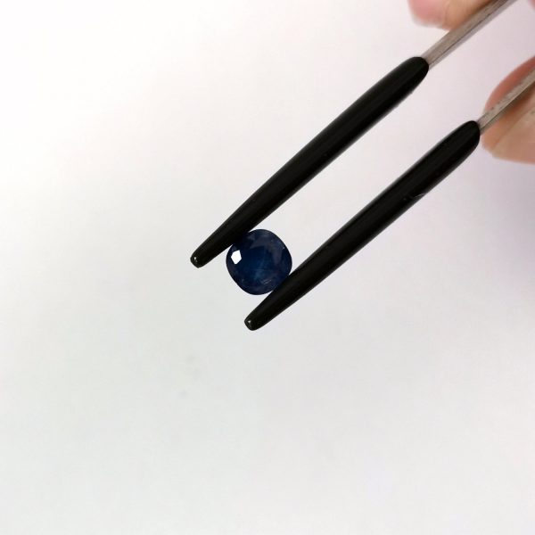 A photo of the crown area of the deep blue sapphire against a white background