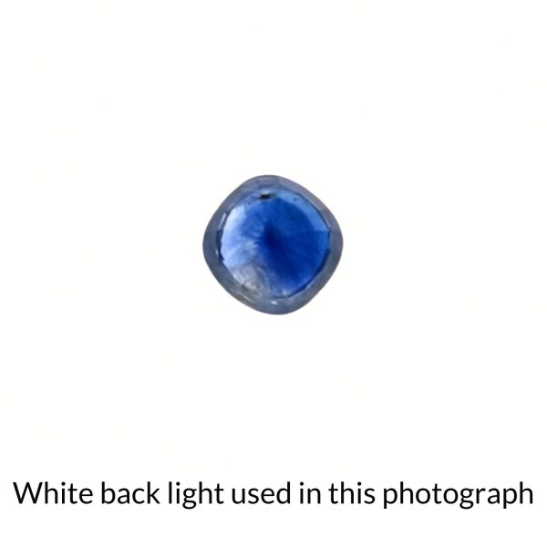 The square shaped blue sapphire gem is being back-lit with a bright white light to show any inclusions within the gem more clearly.