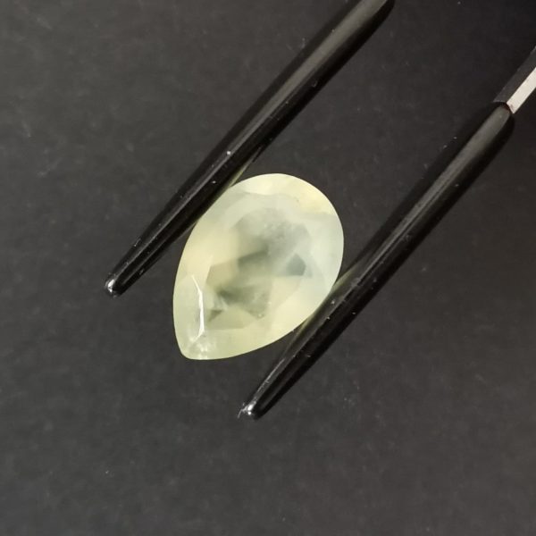 A photo of the crown area of the pale green prehnite against a black background