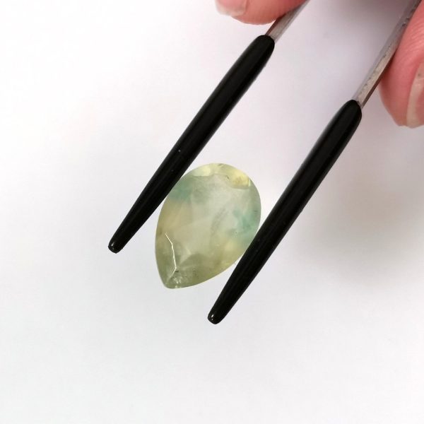 A photo of the crown area of the pale green prehnite against a white background