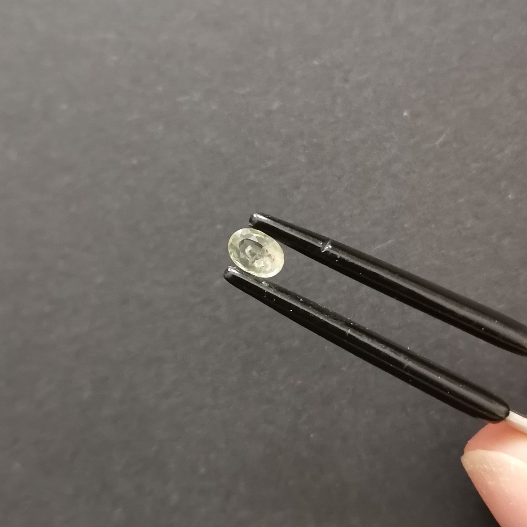 A photo of the crown area of the pale green sapphire against a black background