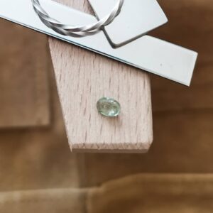 The green sapphire oval displayed on a jewellers bench peg with some sterling silver sheet and wire.