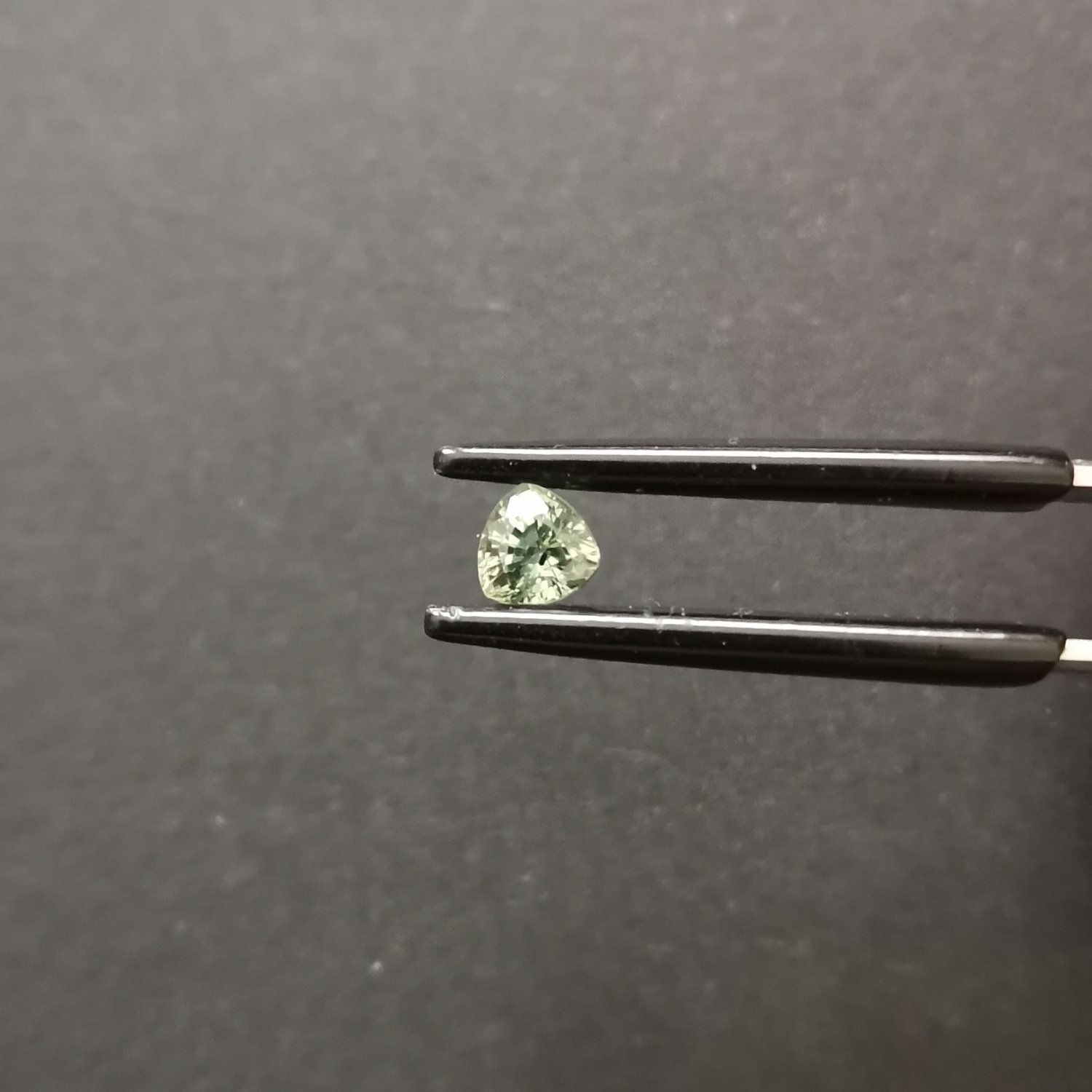A photo of the crown area of the green sapphire against a black background