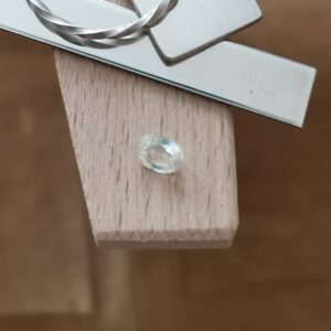 The yellow sapphire oval displayed on a jewellers bench peg with some sterling silver sheet and wire.
