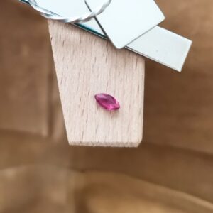 The red ruby marquise displayed on a jewellers bench peg with some sterling silver sheet and wire.