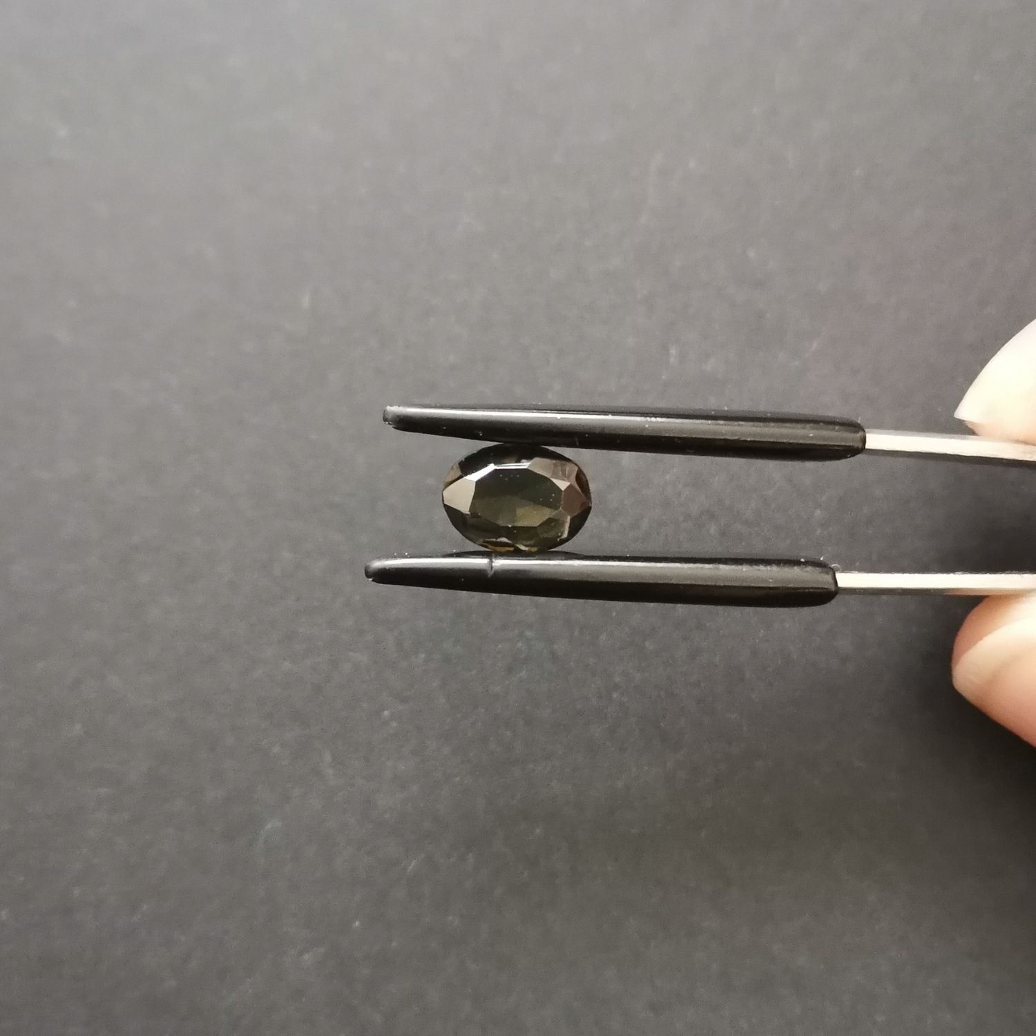 Crown view of the faceted zircon oval against a black background.