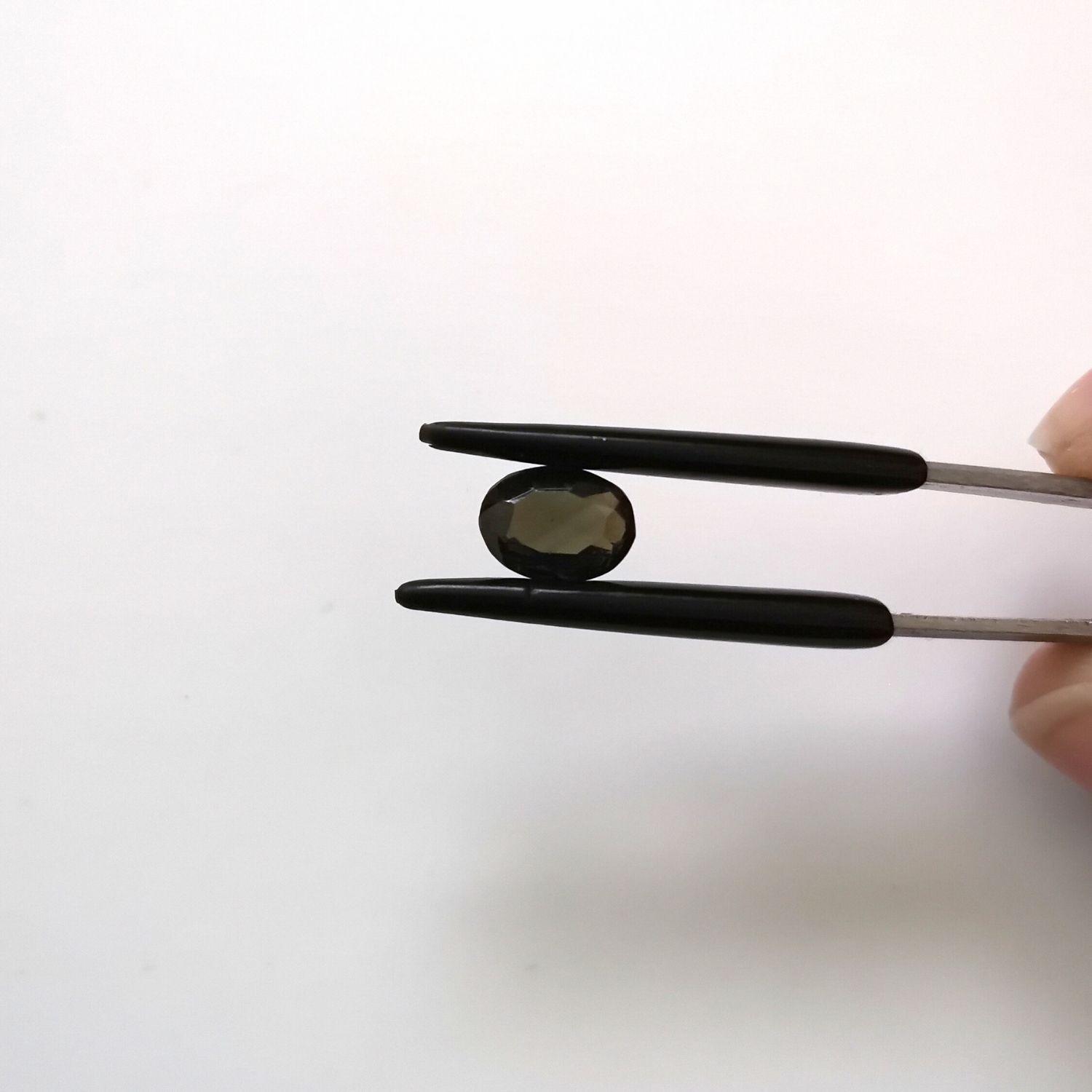 Crown view of the faceted zircon oval against a white background.