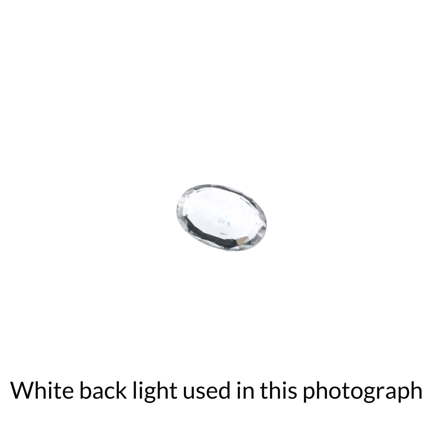 The faceted oval zircon back-lit to highlight inclusions.