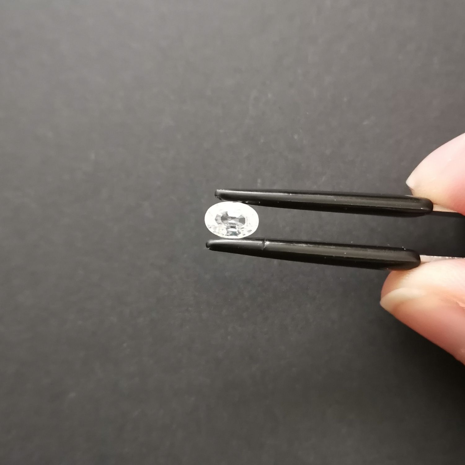 Crown view of the faceted zircon oval against a black background.