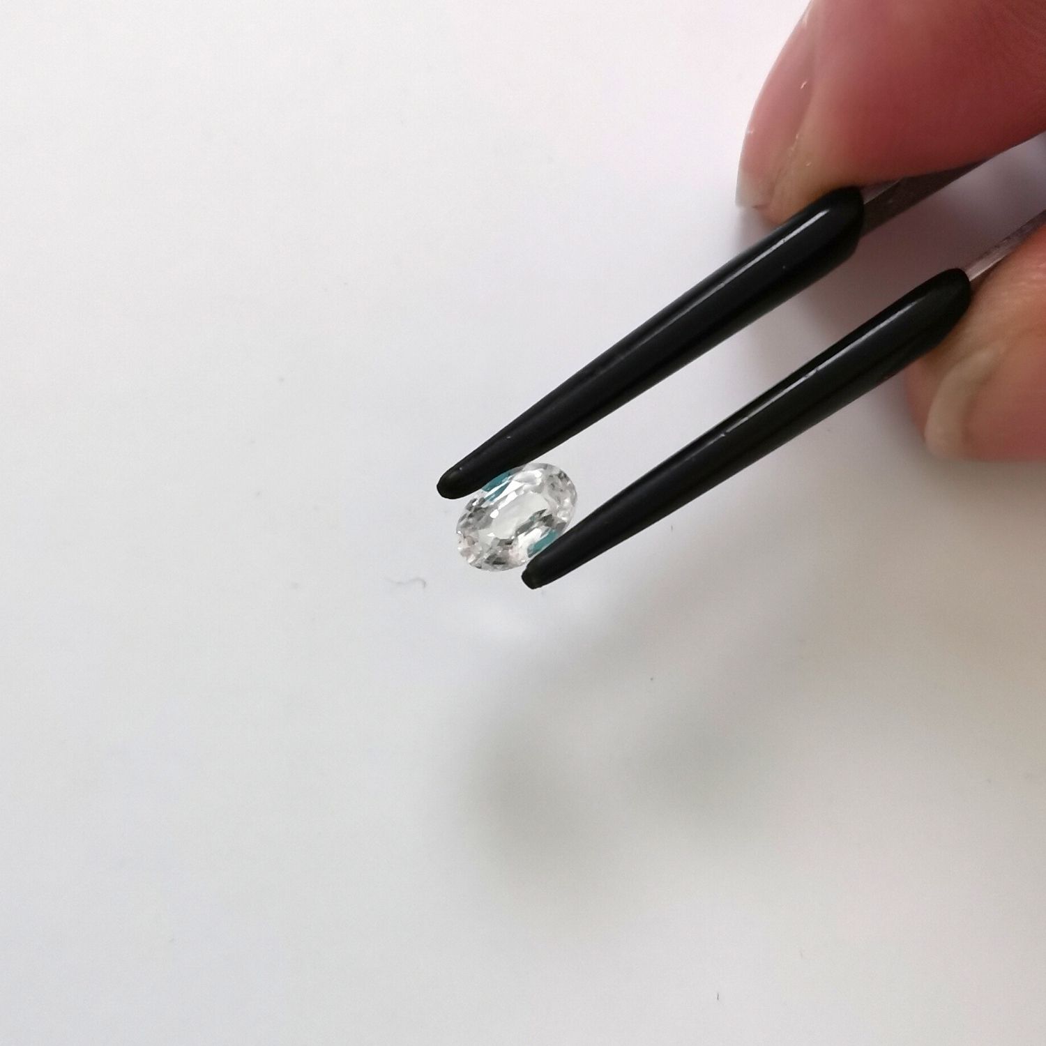 Crown view of the faceted zircon oval against a white background.