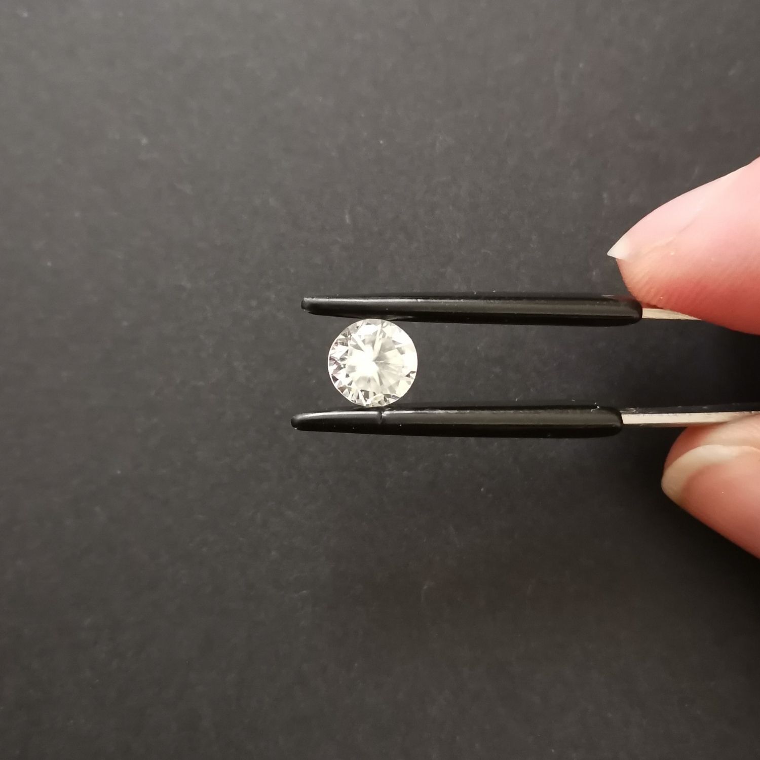 Crown view of the faceted zircon round against a black background.