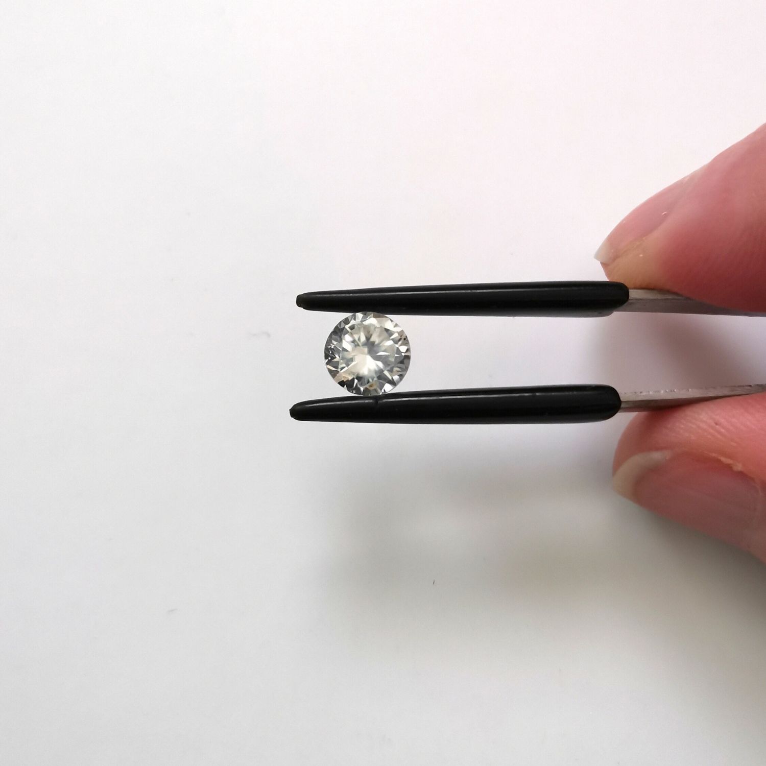 Crown view of the faceted zircon round against a white background.